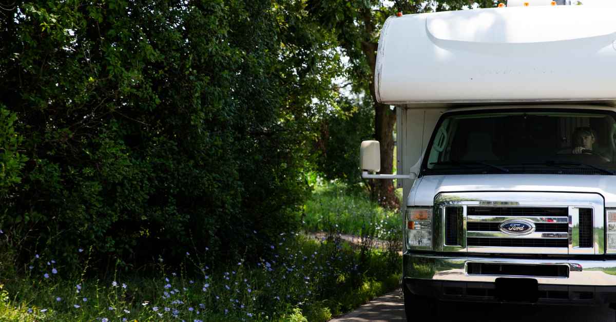 Ford RV driving down wooded country road