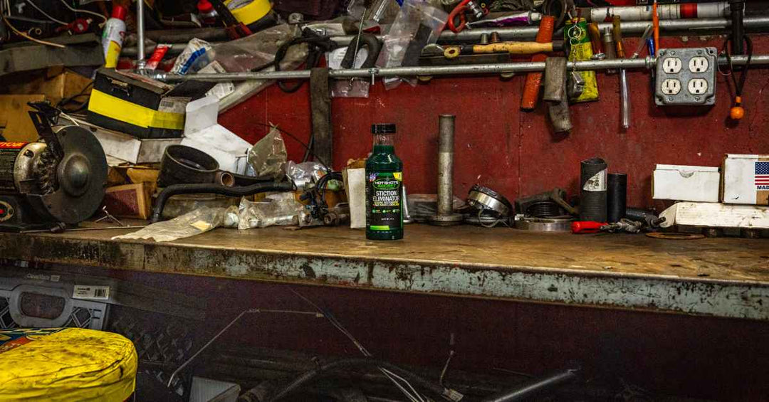Bottle of Stiction Eliminator on a messy workbench in a garage