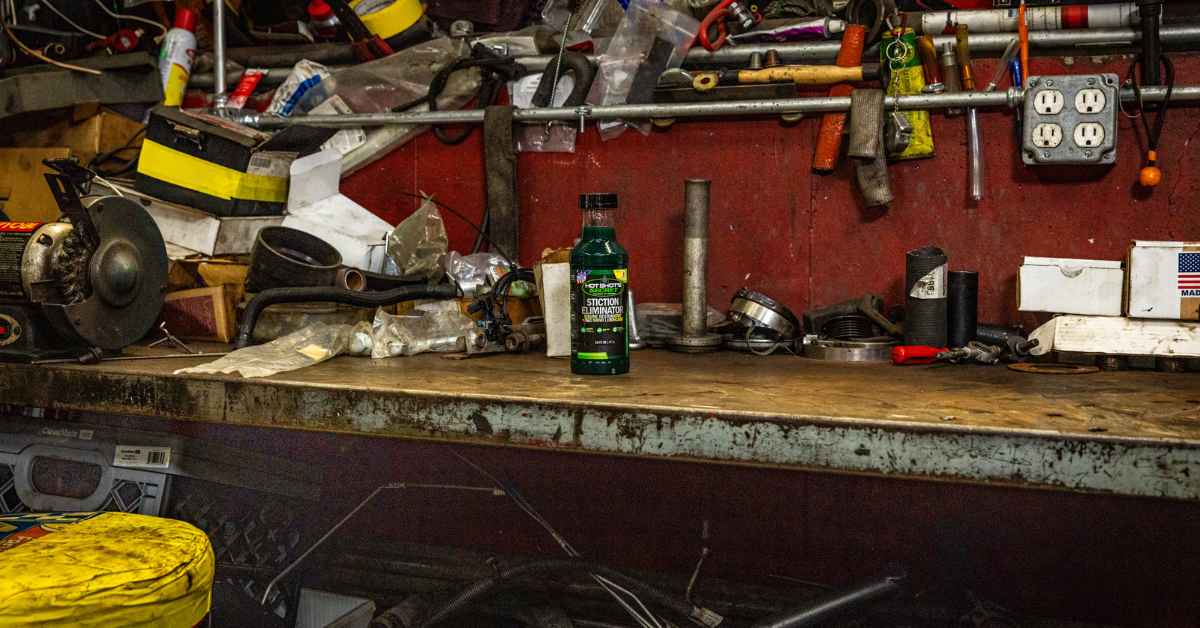 Bottle of Stiction Eliminator on a messy workbench in a garage